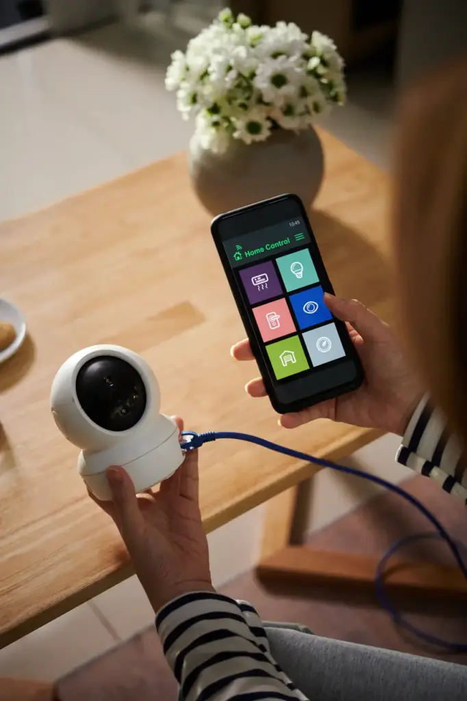 Woman connecting security camera to smartphone 2025 01 30 12 08 16 utc